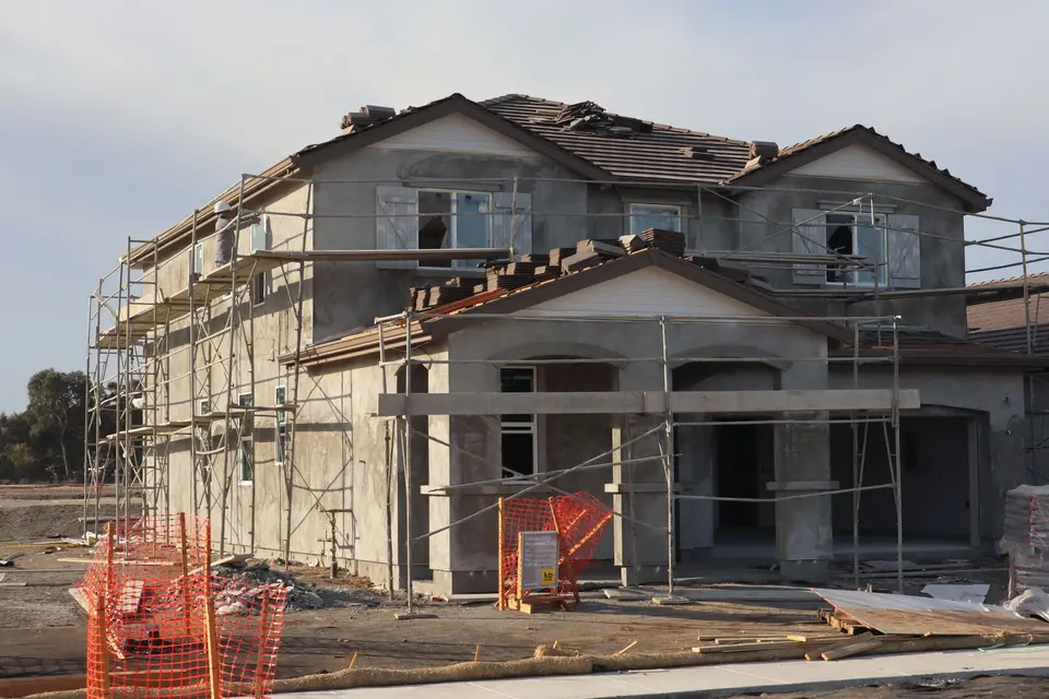 Maison à étage en chantier, entourée d'un échafaudage